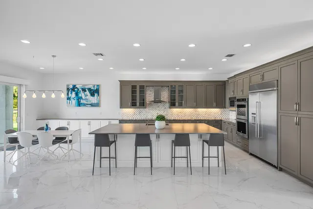 a living room with furniture large windows and wooden floor