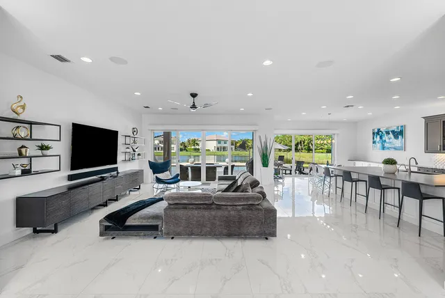 a living room with furniture kitchen view and large windows