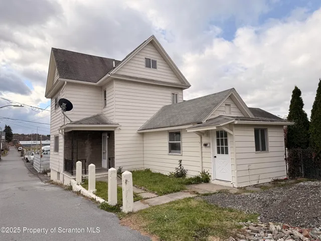 a view of a house with a yard and large tree
