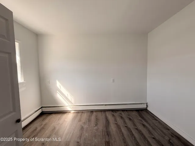 a view of an empty room and wooden floor