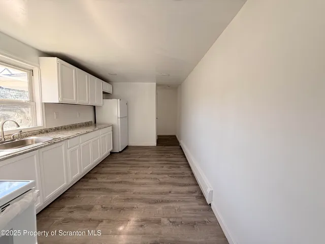 a kitchen with a sink and wooden floor