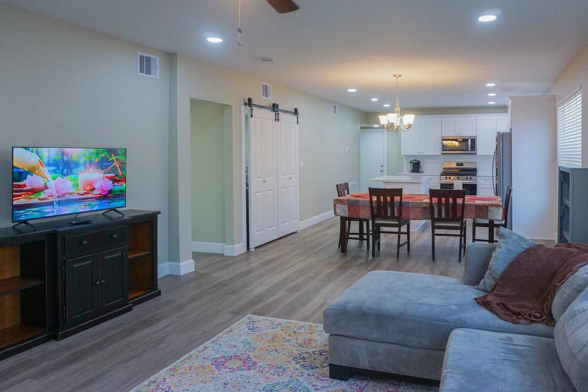 3703 Market Street, Unit 1 Houston, TX 77020 - Photo 2 of 23 Modern open-concept living area featuring a cozy sectional, stylish kitchen, and inviting dining space, perfect for relaxation and entertaining.