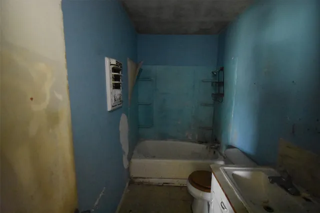 a bathroom with a tub toilet and sink