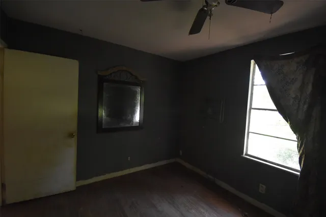 a view of a small space with wooden floor and a window
