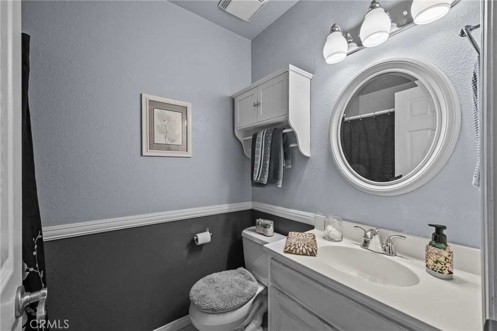 1763 Gleason Street Corona, CA 92882 - Photo 24 of 41 a bathroom with a toilet a sink mirror and vanity