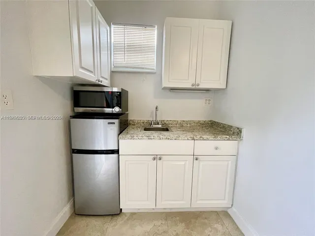 a kitchen with appliances a sink and cabinets