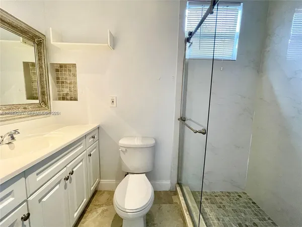 a bathroom with a toilet a sink and a window