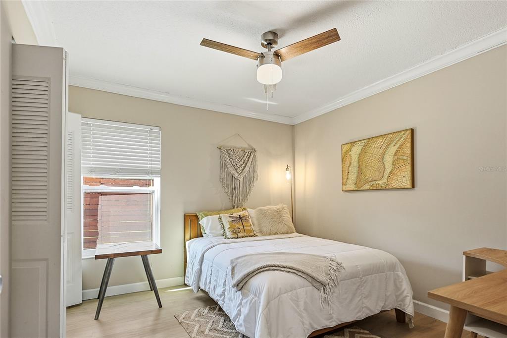 4606 Buckeye Road Tampa, FL 33624 - Photo 29 of 39 a bedroom with a bed and a lamp on a dresser