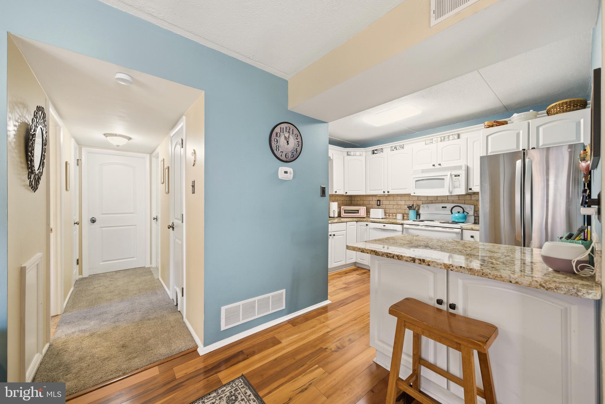 844 Putnam Boulevard, Unit 61A Wallingford, PA 19086 - Photo 12 of 23 a kitchen with stainless steel appliances granite countertop a refrigerator and a stove top oven