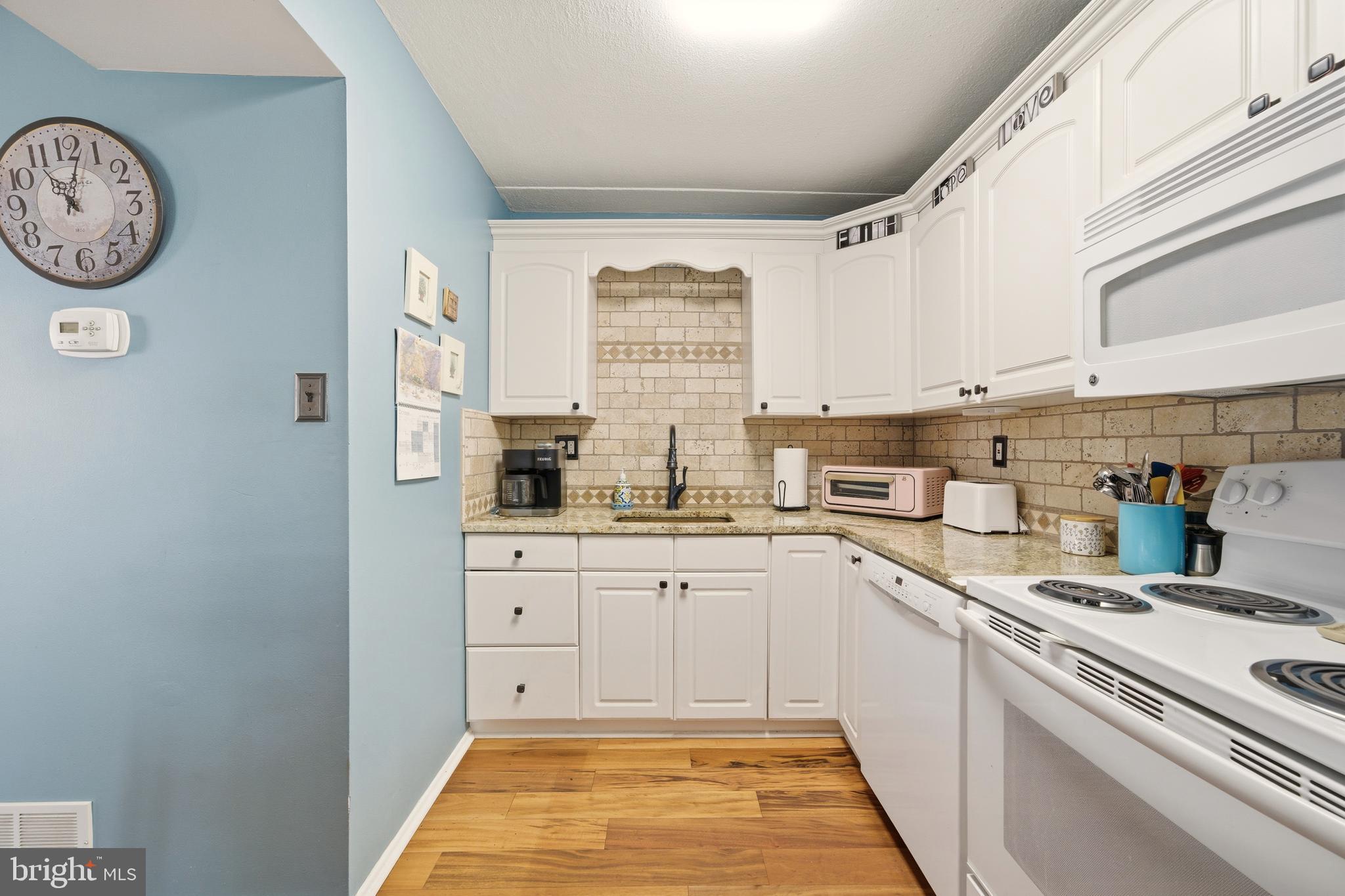844 Putnam Boulevard, Unit 61A Wallingford, PA 19086 - Photo 15 of 23 a kitchen with a white cabinets and white appliances
