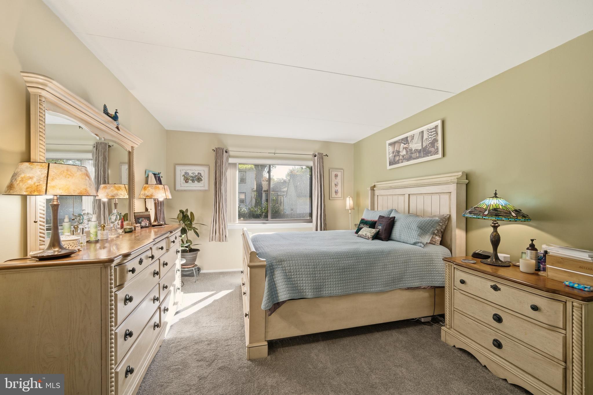 844 Putnam Boulevard, Unit 61A Wallingford, PA 19086 - Photo 19 of 23 a bedroom with a bed and large windows