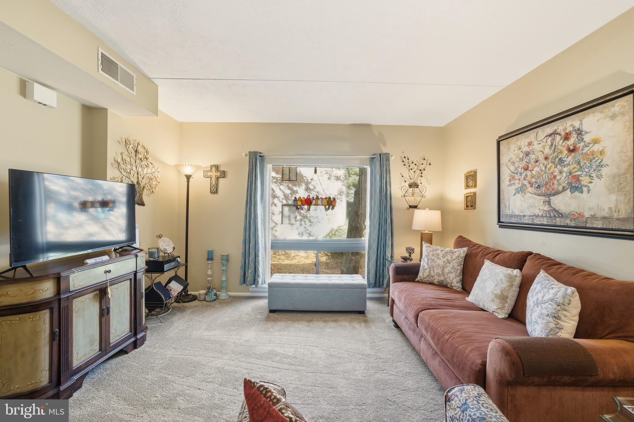 844 Putnam Boulevard, Unit 61A Wallingford, PA 19086 - Photo 7 of 23 a living room with furniture and a flat screen tv