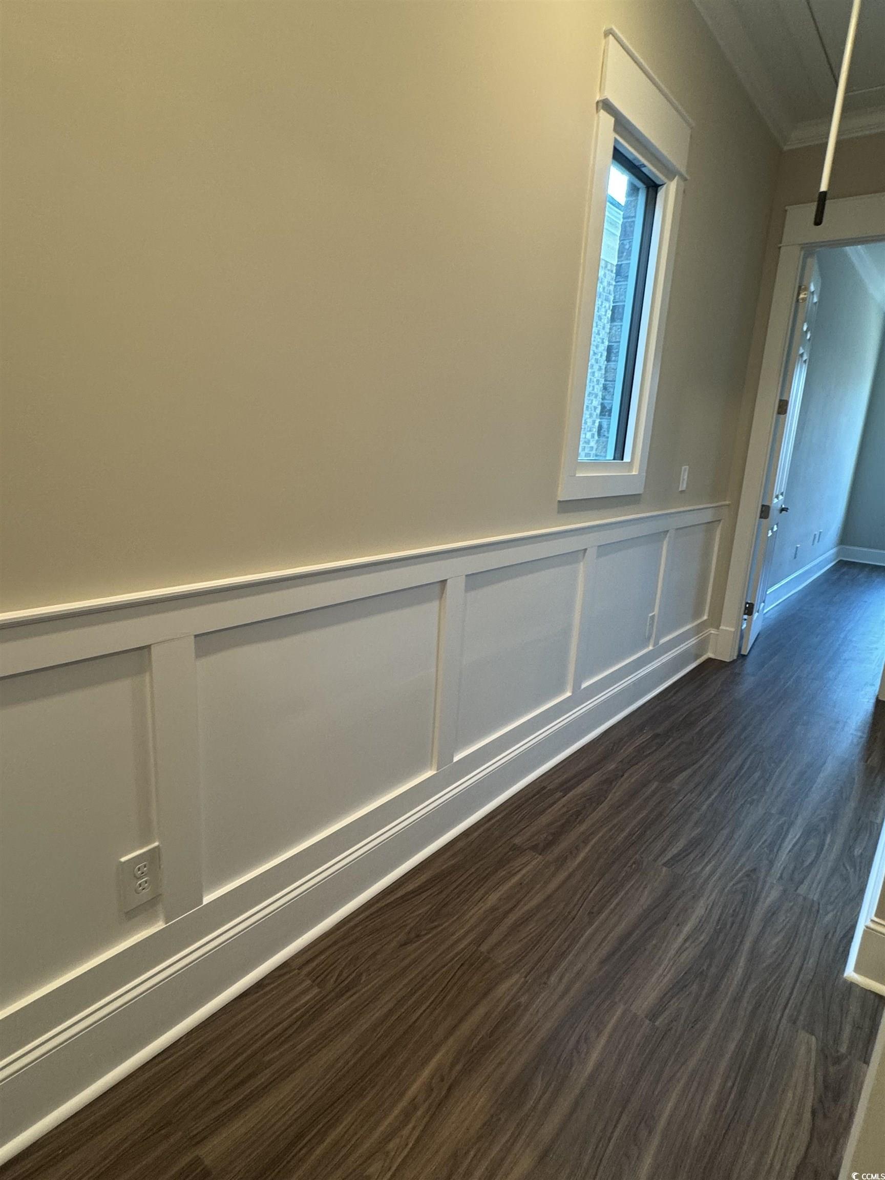 852 Iris Street, Unit D Myrtle Beach, SC 29577 - Photo 16 of 36 Unfurnished room with ornamental molding, dark wood-style flooring, and wainscoting