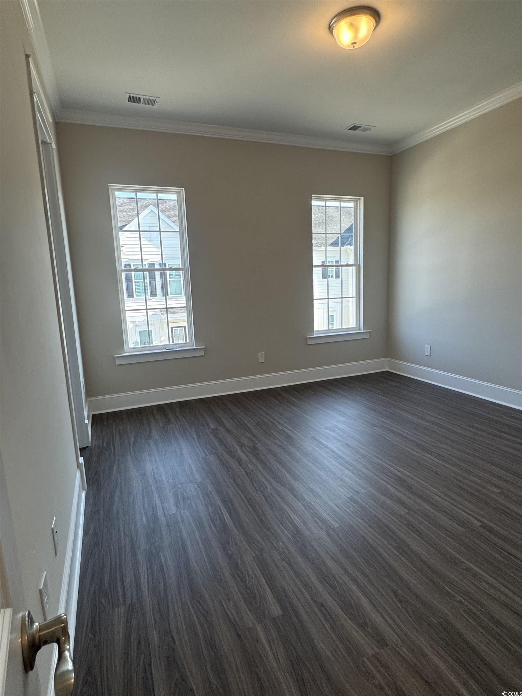 852 Iris Street, Unit D Myrtle Beach, SC 29577 - Photo 18 of 36 Empty room featuring crown molding and dark wood-type flooring