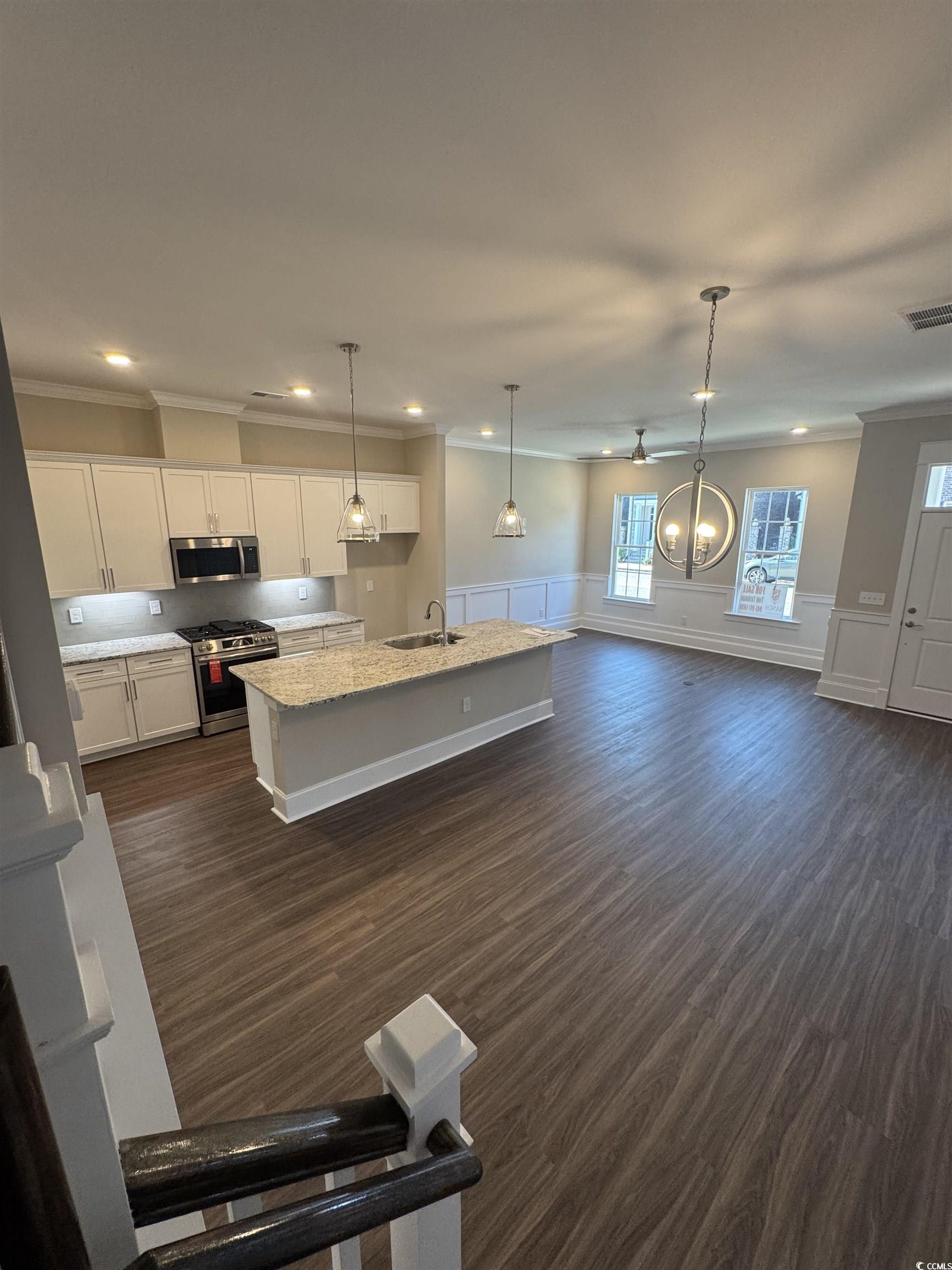 852 Iris Street, Unit D Myrtle Beach, SC 29577 - Photo 26 of 36 Kitchen with appliances with stainless steel finishes, dark wood finished floors, recessed lighting, white cabinetry, and an island with sink