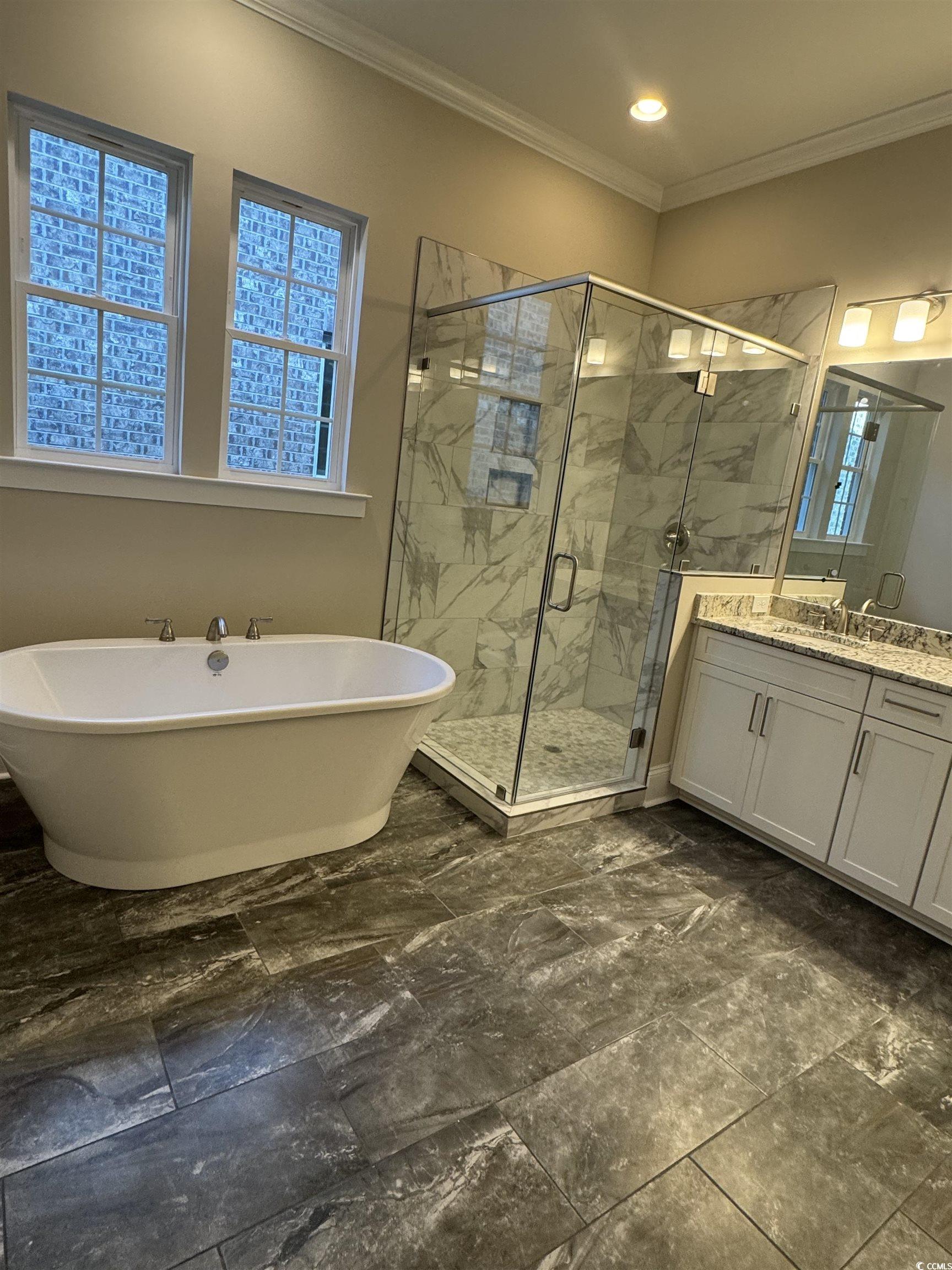 852 Iris Street, Unit D Myrtle Beach, SC 29577 - Photo 9 of 36 Bathroom with vanity, a freestanding tub, ornamental molding, a marble finish shower, and marble look tiles