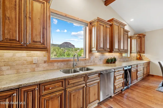 a kitchen with stainless steel appliances a sink a stove and cabinets