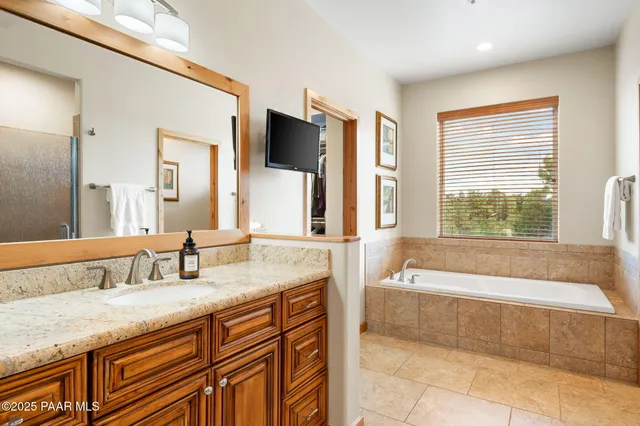 a bathroom with a granite countertop bathtub sink and mirror