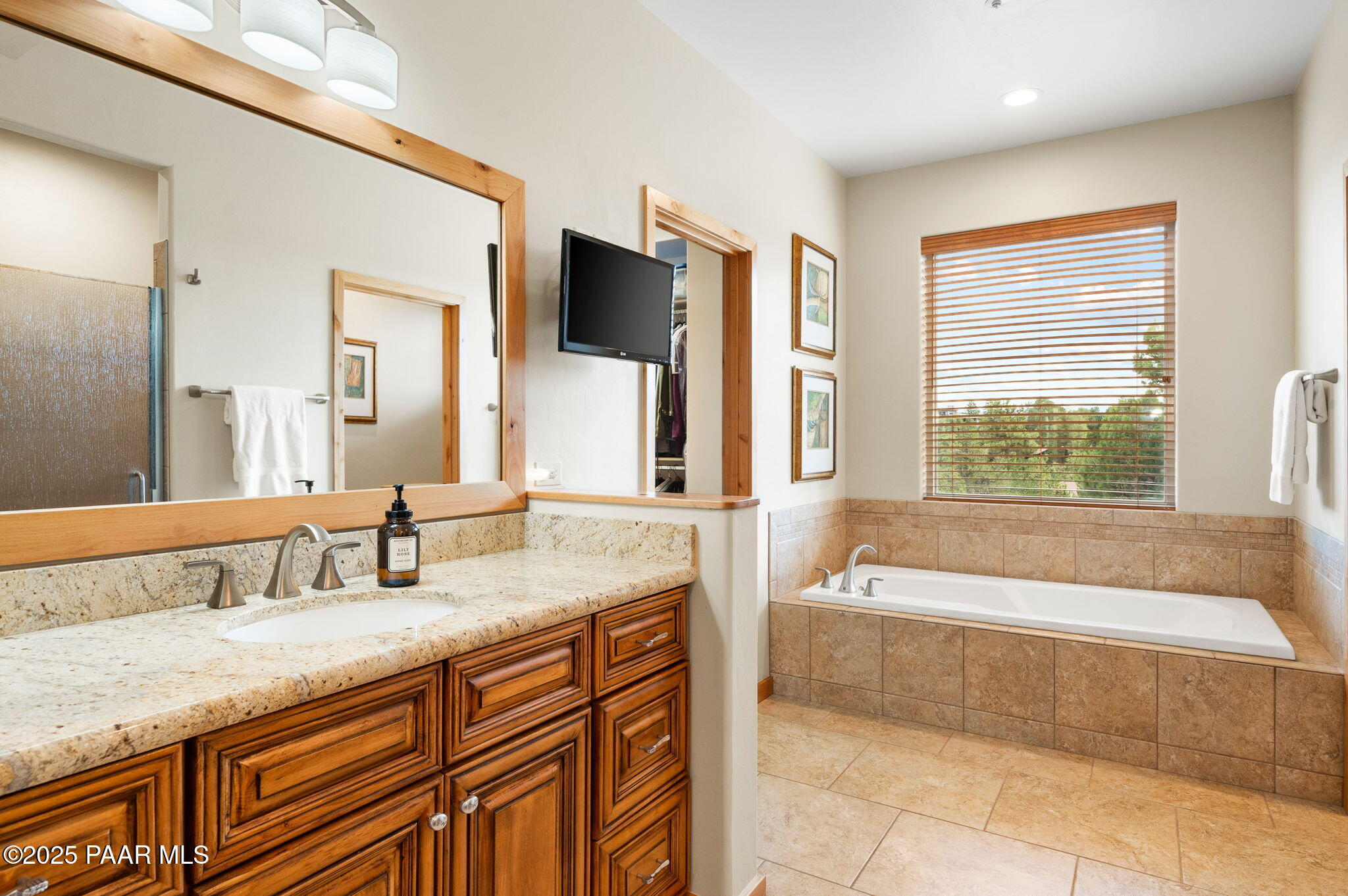 2214 Lichen Ridge Lane Prescott, AZ 86303 - Photo 23 of 46 a bathroom with a granite countertop bathtub sink and mirror