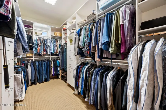 a view of walk in closet with clothes and shoes