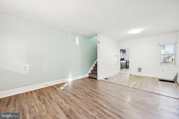 a view of empty room with wooden floor
