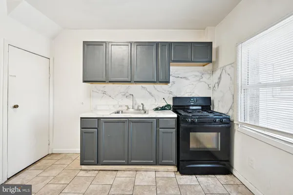 a kitchen with granite countertop a stove sink and cabinets