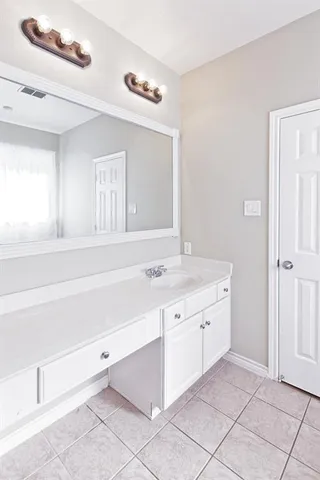 a bathroom with a sink vanity and a mirror