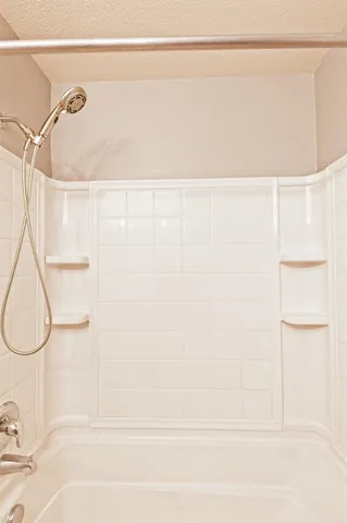 an empty room with a window and a ceiling fan