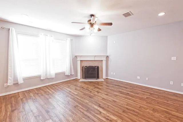 wooden floor fireplace and windows in an empty room