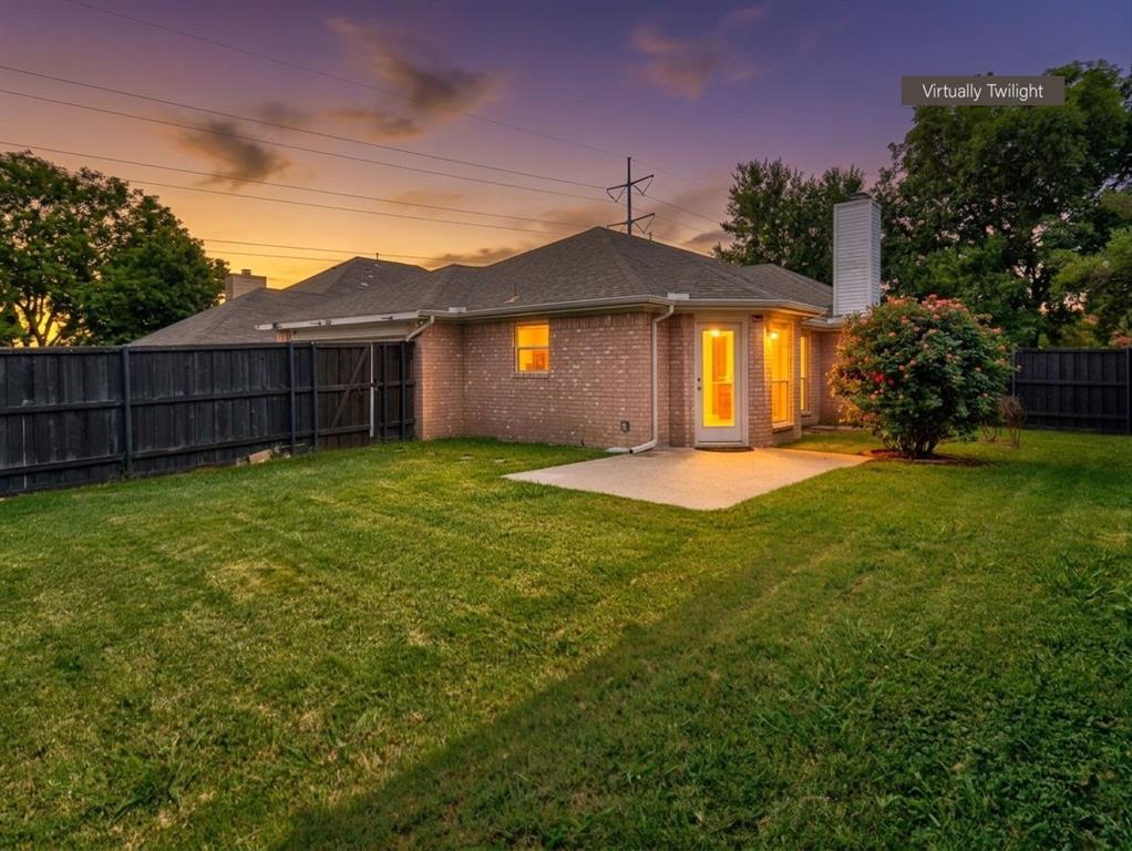 12000 Port Road Frisco, TX 75035 - Photo 38 of 40 Expansive rear yard featuring a brick facade, full privacy fencing, a concrete patio, and a mature flowering shrub