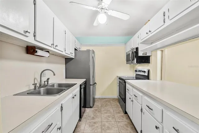 a kitchen with kitchen island granite countertop a sink stainless steel appliances cabinets and a counter top space