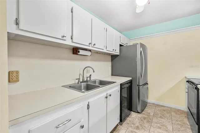 a kitchen with stainless steel appliances granite countertop a sink a refrigerator and cabinets