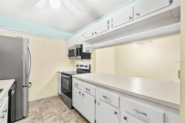 a kitchen with stainless steel appliances a refrigerator sink and white cabinets