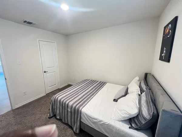 a bedroom with a bed and flat screen tv