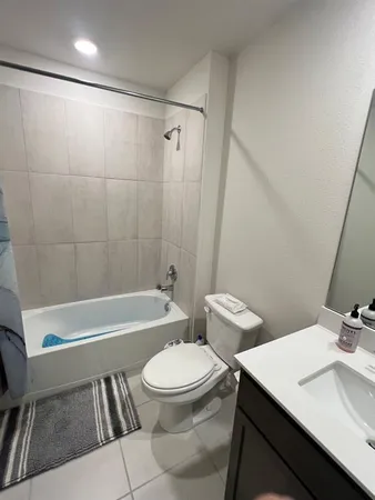 a bathroom with a sink a toilet a mirror and shower