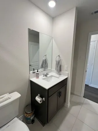 a bathroom with a toilet sink and mirror