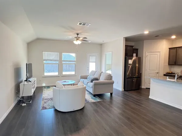 a living room with furniture and a wooden floor