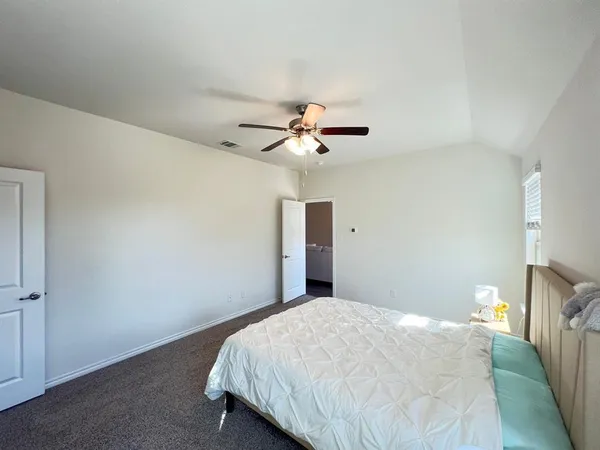 a bedroom with a bed and a ceiling fan