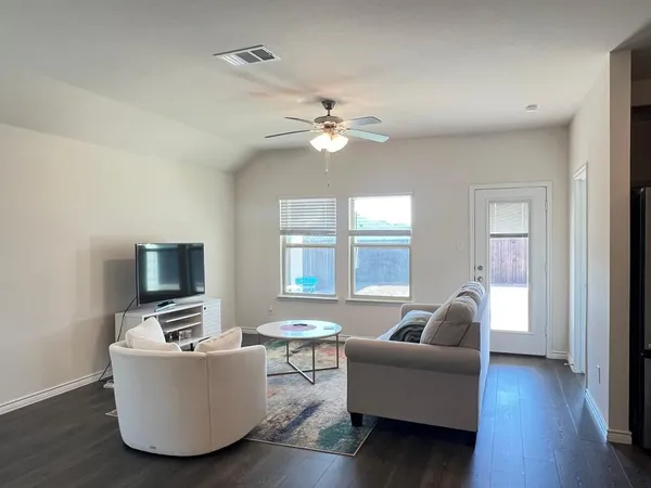a living room with furniture a fireplace and a flat screen tv