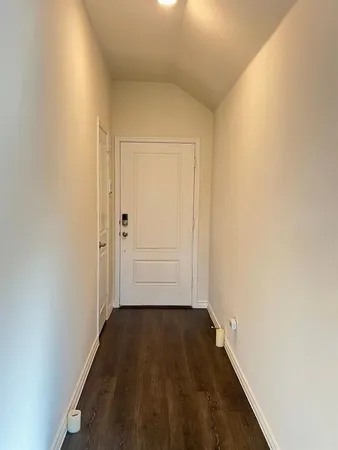 a view of a hallway with wooden floor