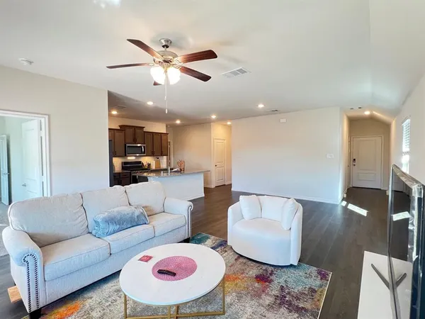 a living room with furniture and a view of kitchen