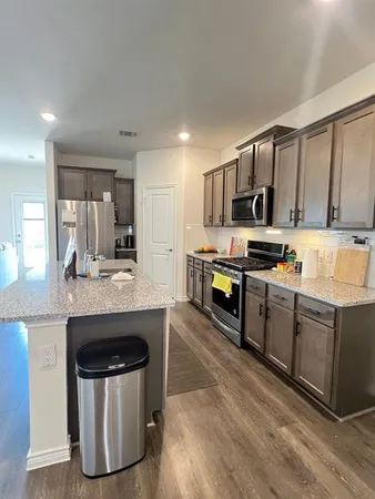 a kitchen with stainless steel appliances a stove a sink and a microwave