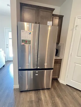 a view of a refrigerator in kitchen and wooden floor