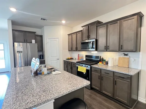 a kitchen with a stove a sink and cabinets