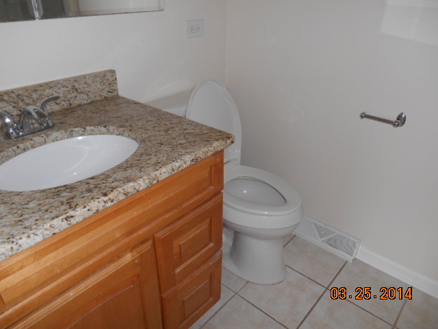 9 Edgewood Road Vernon Hills, IL 60061 - Photo 10 of 13 a bathroom with a granite countertop toilet and a sink
