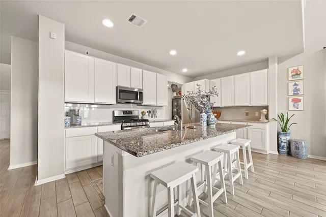 a kitchen with stainless steel appliances granite countertop a stove sink and cabinets