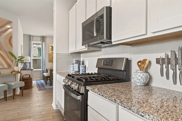 a kitchen with sink stove and living room