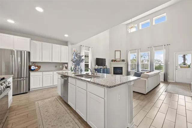 a bedroom with a large bed and a chandelier fan