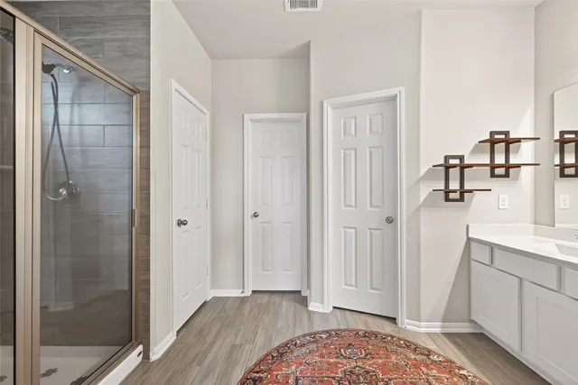 a bathroom with a double vanity sink a mirror and shower