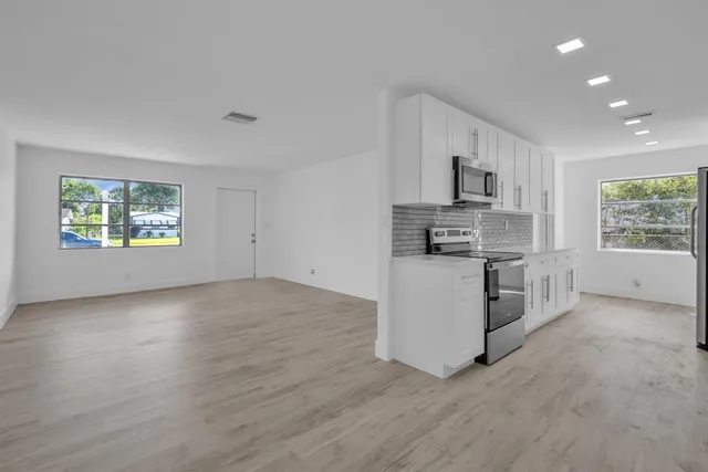 a kitchen with stainless steel appliances a stove a sink and a microwave